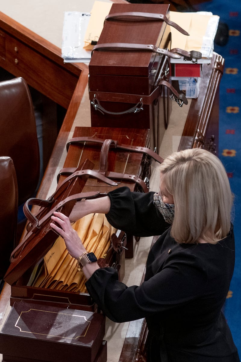 FILE – Boxes containing Electoral College votes are opened as a joint session of the House and Senate convenes to confirm the electoral votes cast in November’s election, at the Capitol, Jan 6, 2021. (AP Photo/Andrew Harnik, File)