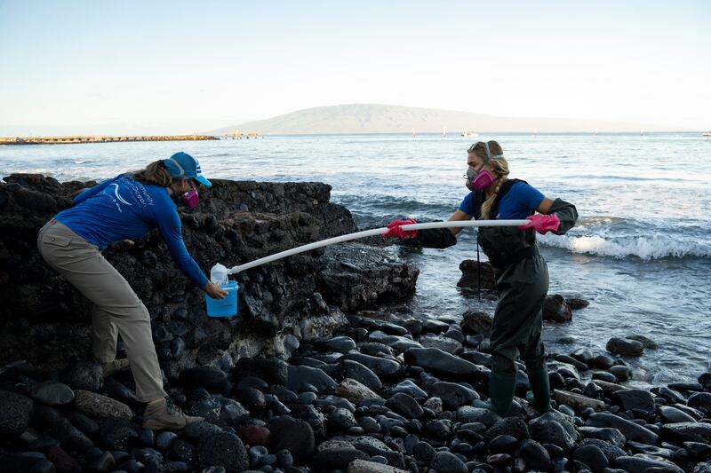 Tova Callender, left, and Christiane Keyhani collect water samples in Lahaina (Mengshin Lin/AP)