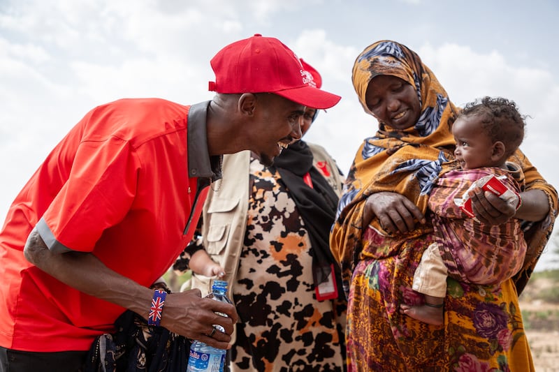 Sir Mo Farah meets a malnourished child being helped by Save The Children (Save The Children)