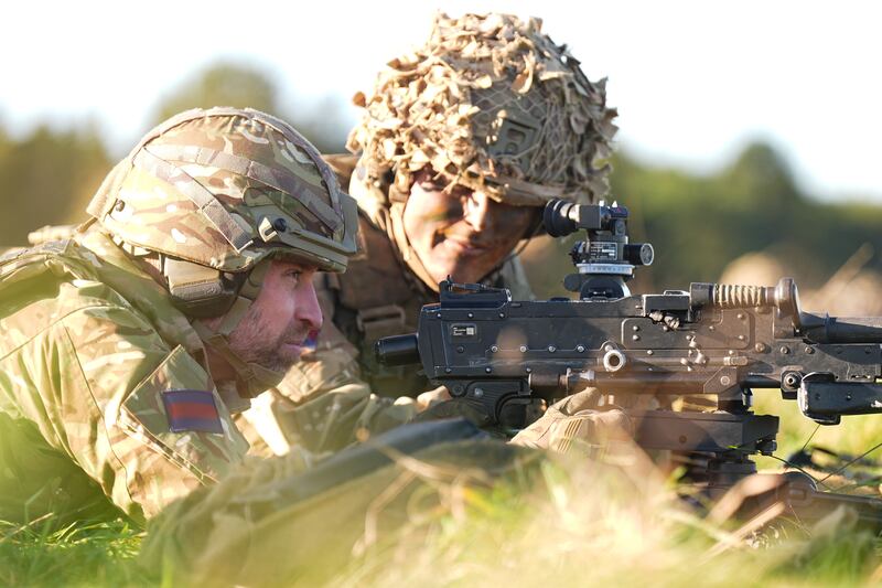 The Prince of Wales (left) tries out a general-purpose machine gun