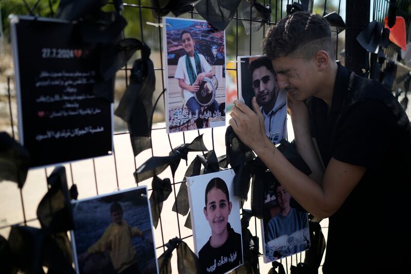 A youth from the Druze minority weeps over a makeshift memorial for 12 children and teens killed in a rocket strike on a soccer field in the Israeli-annexed Golan Heights (Leo Correa/AP)