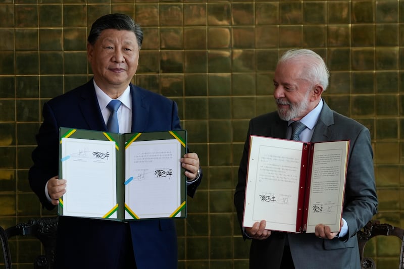 President Xi Jinping and President Luiz Inacio Lula da Silva pose for photos with their bi-lateral agreements at the Alvorada palace in Brasilia, Brazil (Eraldo Peres/AP)