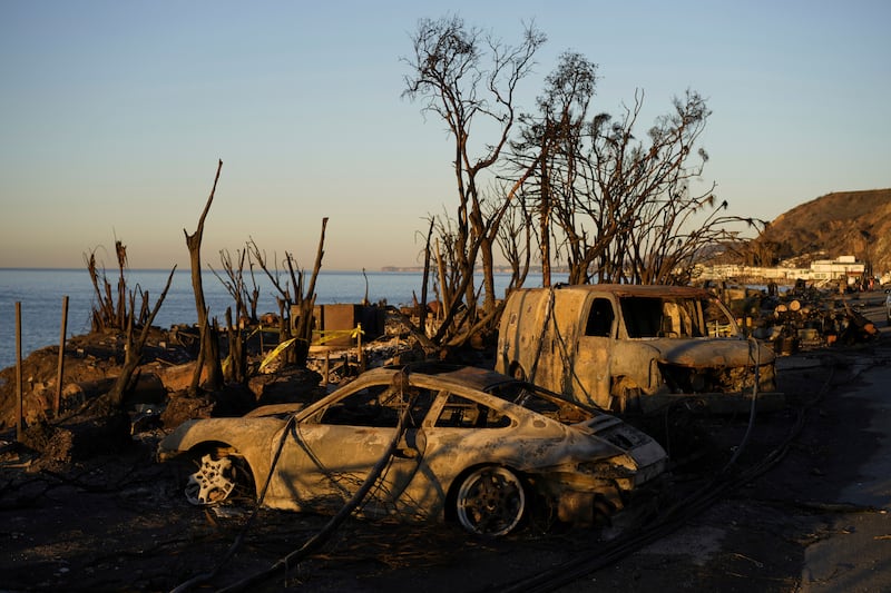 Charred vehicles sit along the Pacific Coast Highway in Malibu, California (Carolyn Kaster/AP)