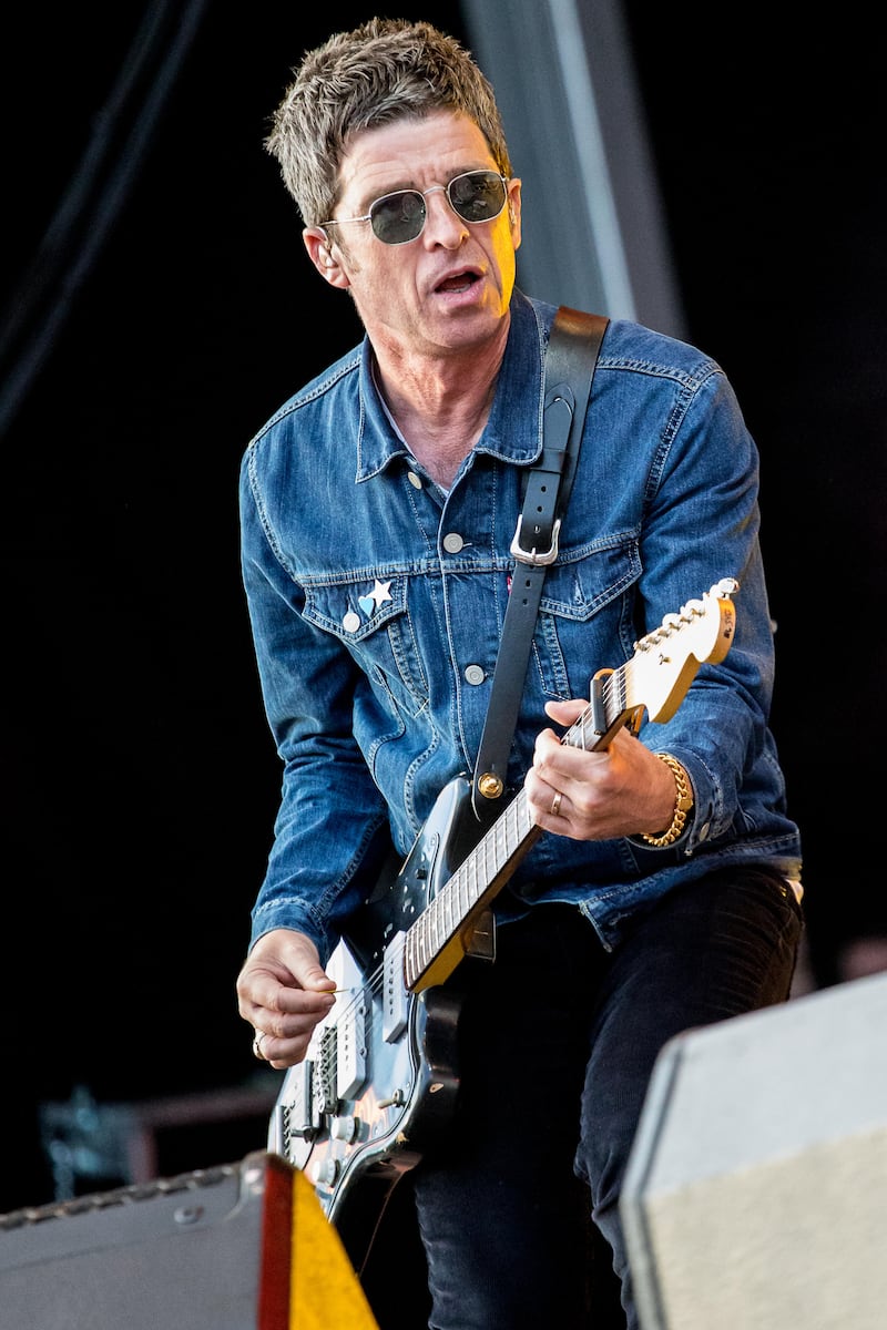 Noel Gallagher often wears navy shirts or denim jackets on stage