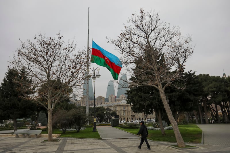 Azerbaijan’s national flag flies at half-mast in the centre of the capital, Baku, in memory of victims of the plane crash (Aziz Karimov/AP)