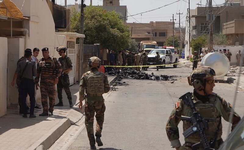 Iraqi Army soldiers stand guard near the debris of a drone shot down by Iraq’s air defences in Kirkuk, Iraq (AP)