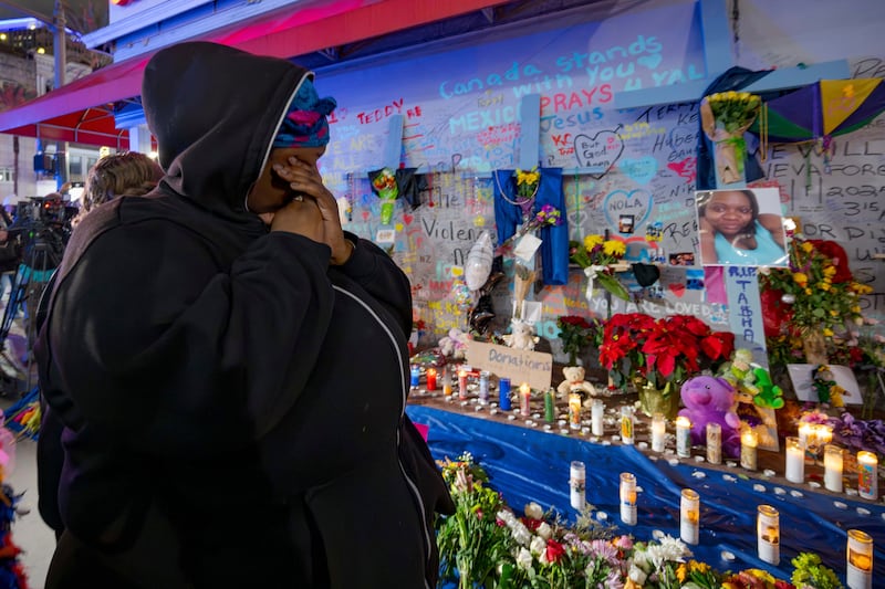 Courtney Polk, a cousin of Tasha Polk, who was killed in the New Year’s Day attack, wipes a tear as she reads messages left in tribute (Matthew Hinton/AP)