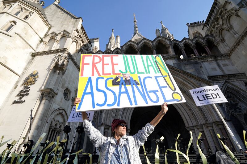 A campaigner holding a sign outside the Royal Courts of Justice in London
