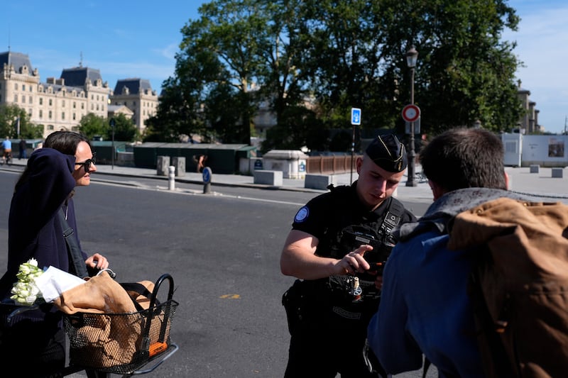 A police officer checks people at the security perimeter (David Goldman/AP)