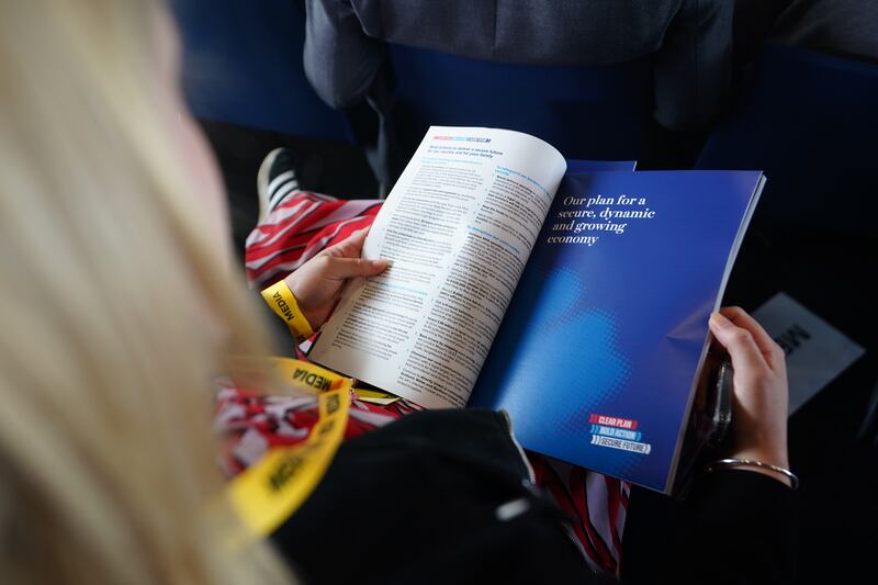 A member of the audience holds a copy of the Conservative Party General Election manifesto