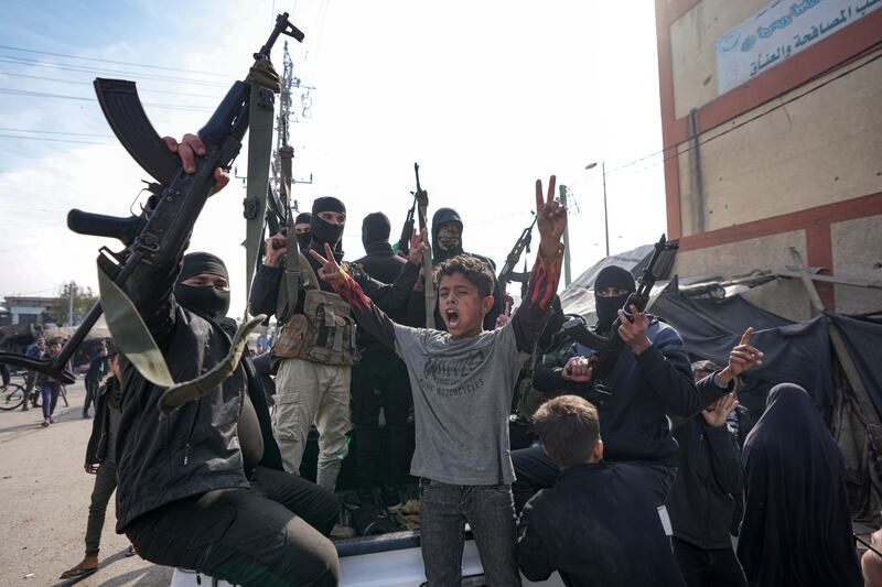 Members of the Izzedine al-Qassam Brigades, the armed wing of Hamas, take part in a parade as they celebrate the start of the ceasefire (Abdel Kareem Hana/AP)