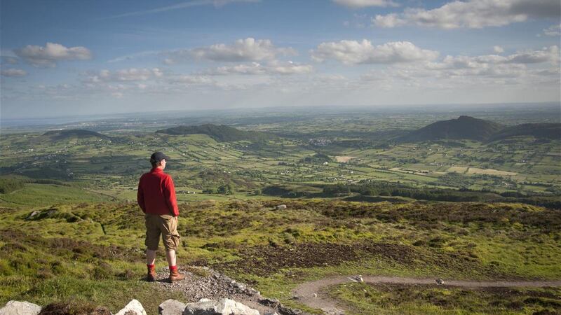 A picture of a man in a read top looking out over the Ring of Gullion