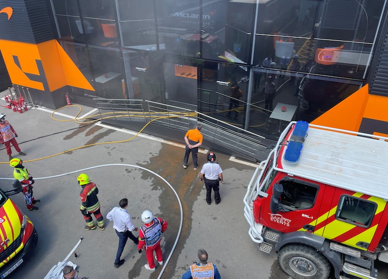 Zak Brown stands outside McLaren’s motorhome following a fire