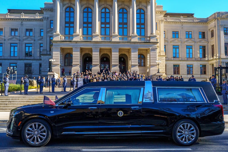 The hearse transporting the body of former US president Jimmy Carter stops at Georgia’s State Capitol for a moment of silence (Matthew Pearson/WABE via AP)