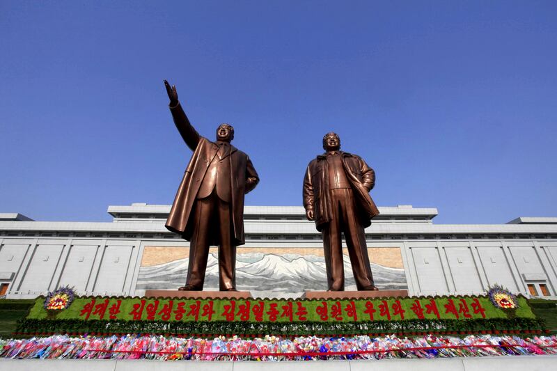 Flowers are laid under bronze statues of North Korea’s late leaders Kim Il Sung, left, and Kim Jong Il at Mansu Hill in Pyongyang (AP)