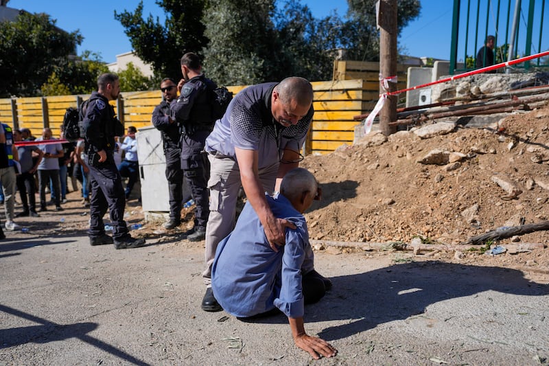 People react at the site where one person was killed after a projectile launched from Lebanon slammed into northern Israel (AP Photo/Ohad Zwigenberg)