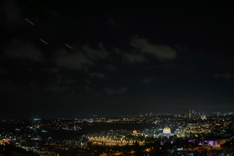 Projectiles fly through the sky over Jerusalem as a siren sounds a warning of incoming missiles fired from Iran, in Jerusalem, on Tuesday (Mahmoud Illean/AP)