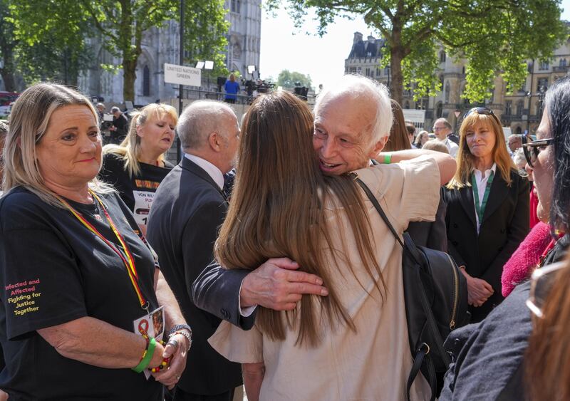 Chairman of the infected blood inquiry Sir Brian Langstaff with victims and campaigners