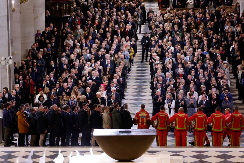 Firefighters, rescuers and builders involved in the restoration get applause in Notre Dame Cathedral (Ludovic Marin, Pool via AP)