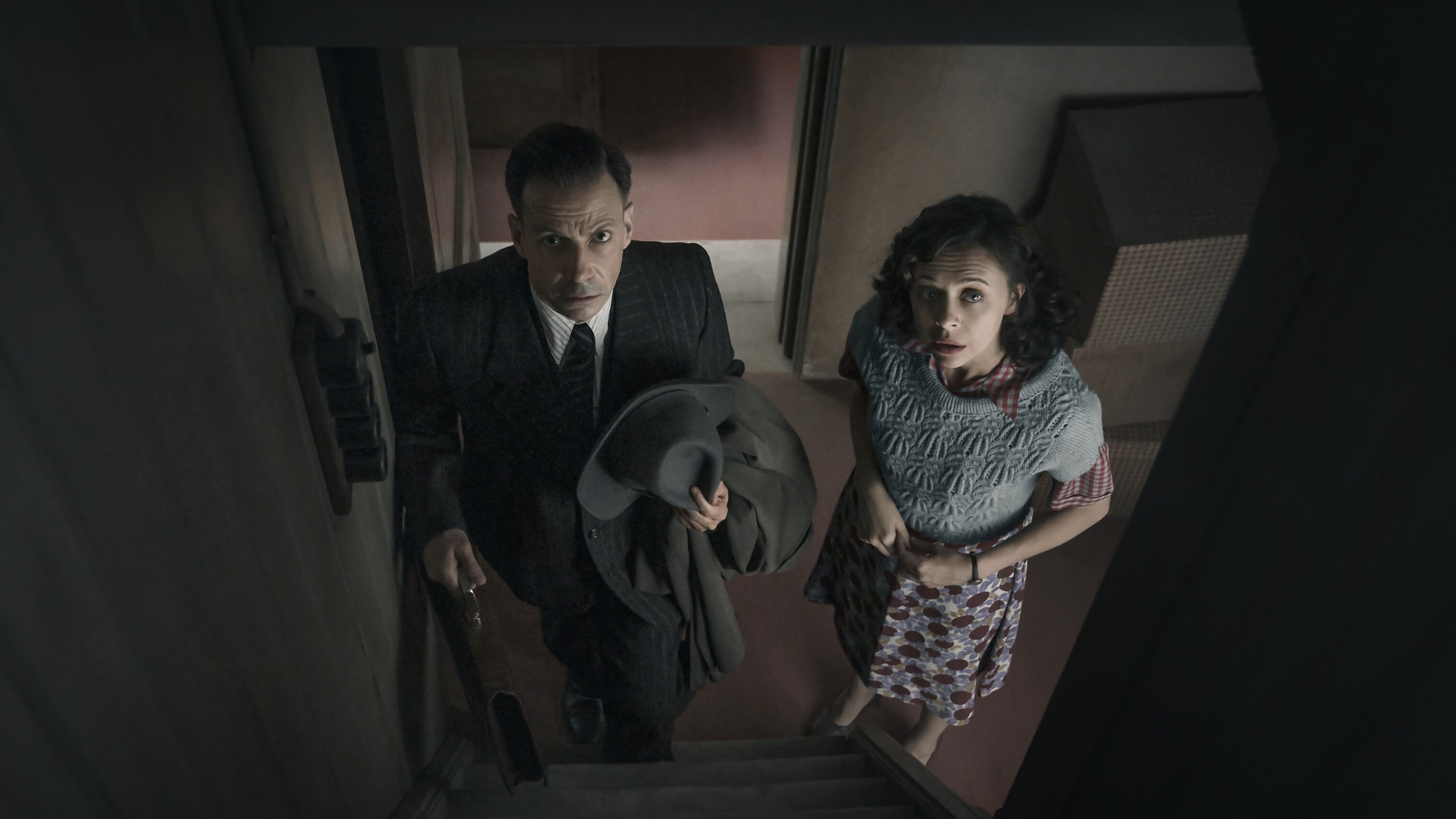 Dr. Pfeffer (Noah Taylor) and Miep Gies (Bel Powley), look up into the secret annex entrance in A Small Light. Picture by National Geographic for Disney/Dusan Martincek