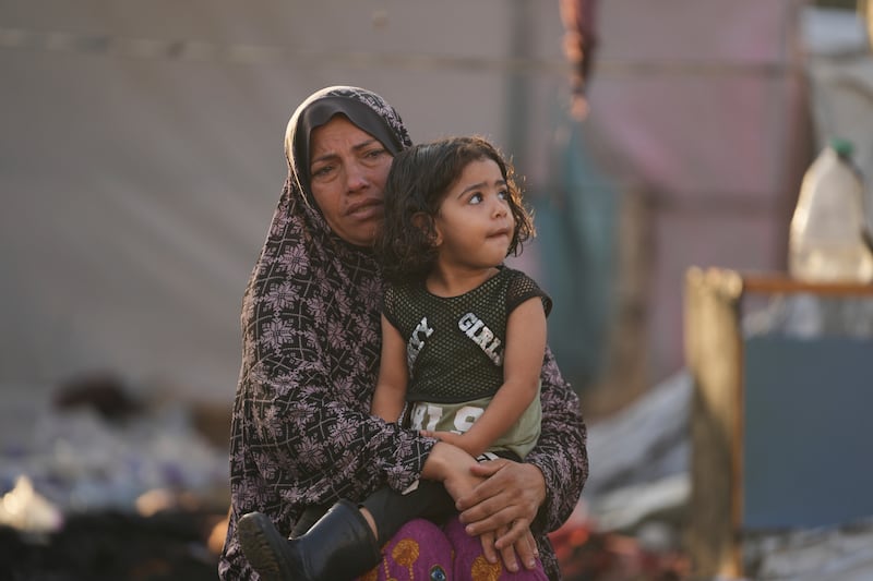 A Palestinian woman and child after an Israeli strike hit a tent area in the courtyard of Al Aqsa Martyrs hospital in Deir al Balah, Gaza, on Monday (Abdel Kareem Hana/AP)