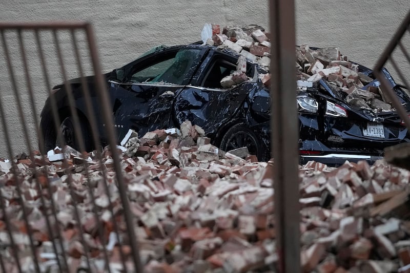 A car damaged by fallen bricks (David J Phillip/AP)