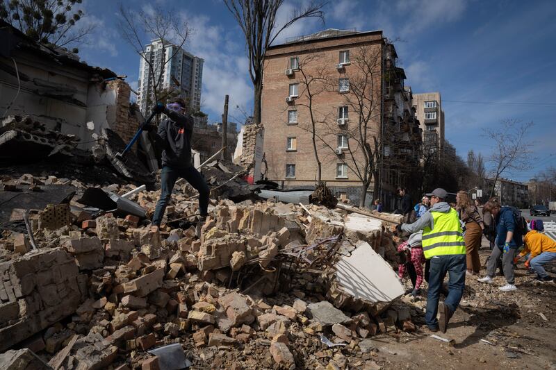 Volunteers and students of the Kyiv State Arts Academy clear the rubble after it was hit during a Russian missile attack (Efrem Lukatsky/AP)