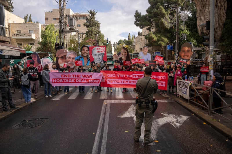 Families and supporters of Israeli hostages held by Hamas in Gaza, hold photos of their loved ones during a protest calling for their release (Ohad Zwigenberg/AP)