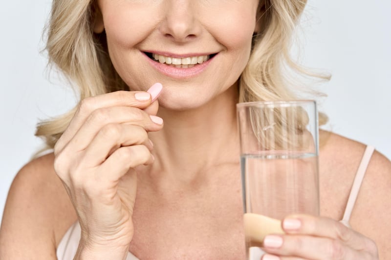 Cropped photo of senior woman taking beauty collagen pills