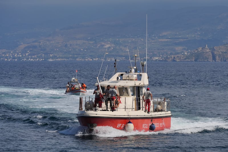 A boat carrying a dive team returns from the site of the Bayesian