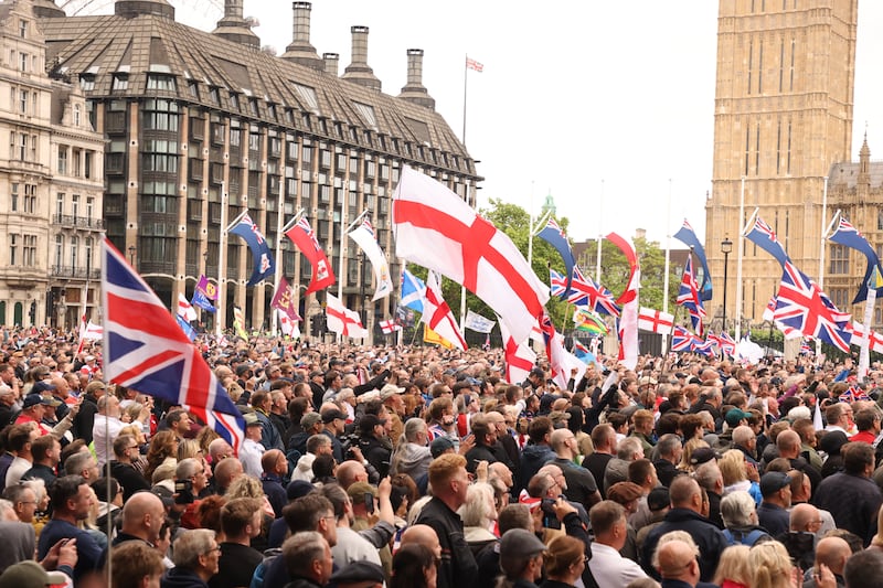 People take part in a protest march at Parliament Square in London, organised by Tommy Robinson, in June