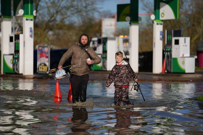 People walk through floodwater near the Billing Aquadrome in Northamptonshire