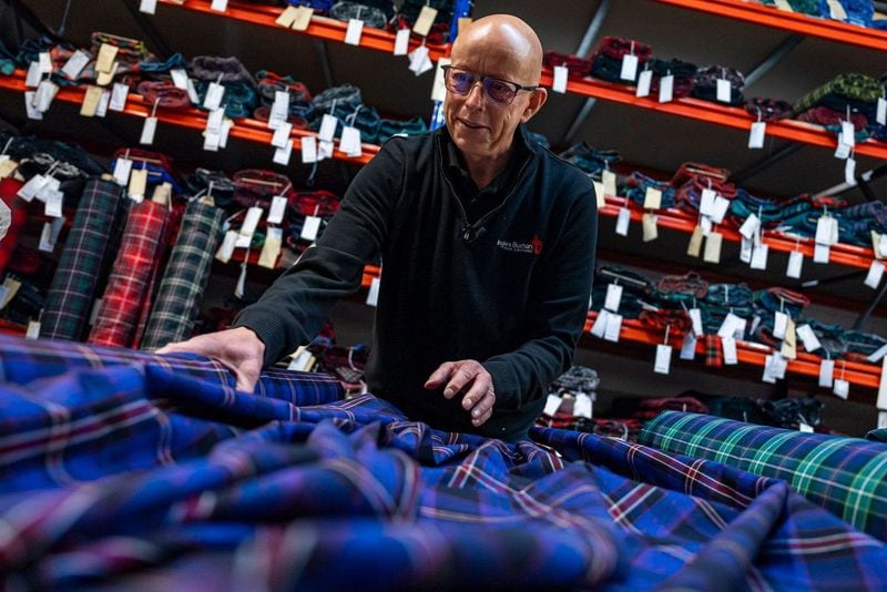 A worker examines the freshly made Interpol tartan.