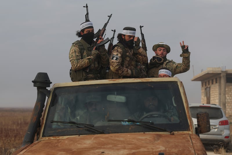 Syrian opposition fighters ride in a truck in Talhiya, Idlib countryside, Syria (Ghaith Alsayed/AP)