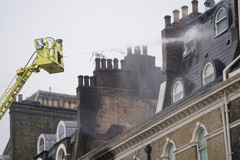Firefighters deal with the aftermath of the blaze that left 13 people suffering from smoke inhalation