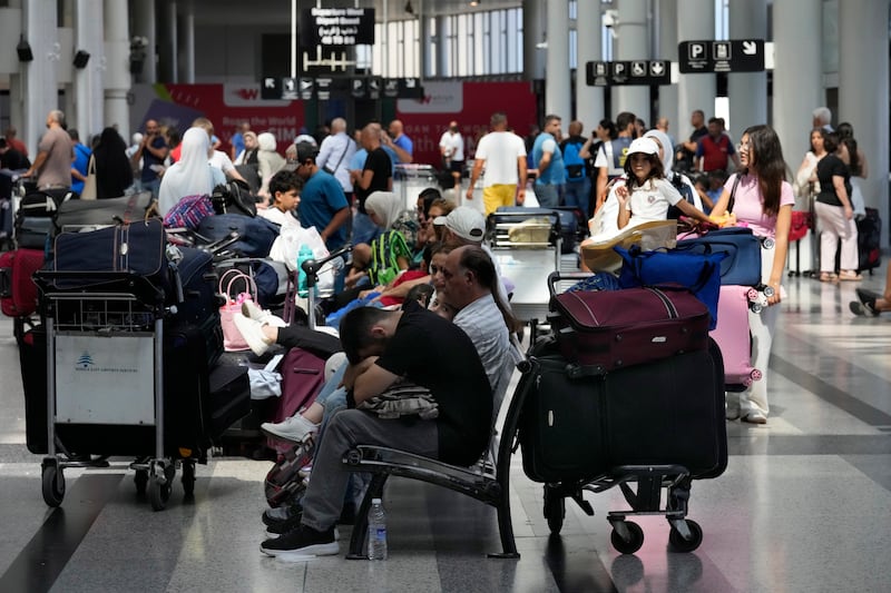 Passengers whose flights were cancelled wait at the departure terminal of Rafik Hariri International Airport in Beirut (Hussein Malla/AP)