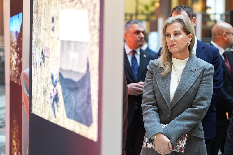 Sophie looks at photographs at the exhibition in the Foreign Office