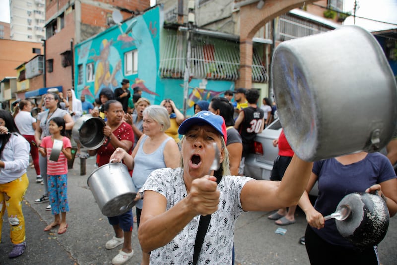 Residents bang pots to protest the day after the presidential election in Caracas (Cristian Hernandez/AP)