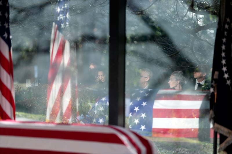 Family members are reflected as they listen during a service at the flag-draped coffin of former US president Jimmy Carter at the Jimmy Carter Presidential Library and Museum in Atlanta (Alex Brandon, Pool/AP)