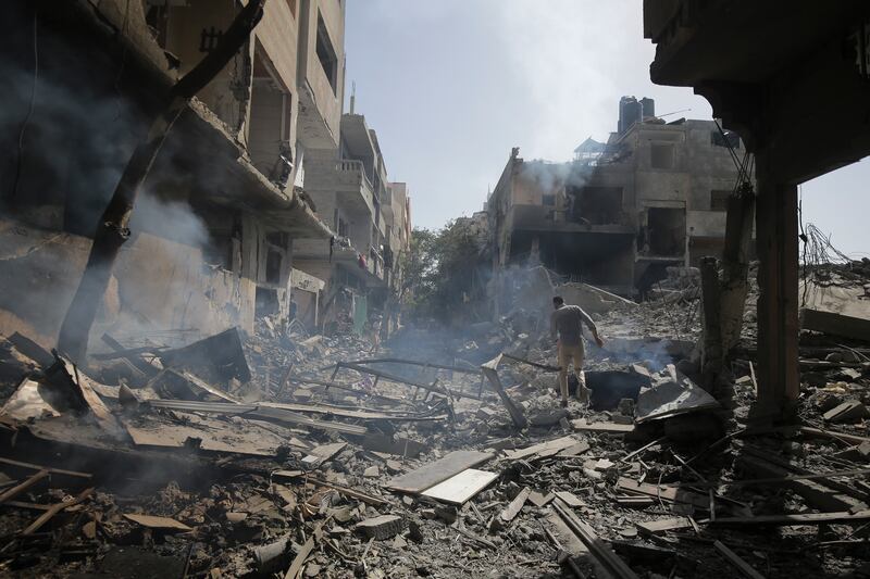 Palestinians look at the aftermath of the Israeli bombing in Nuseirat refugee camp, Gaza Strip (Jehad Alshrafi/AP)