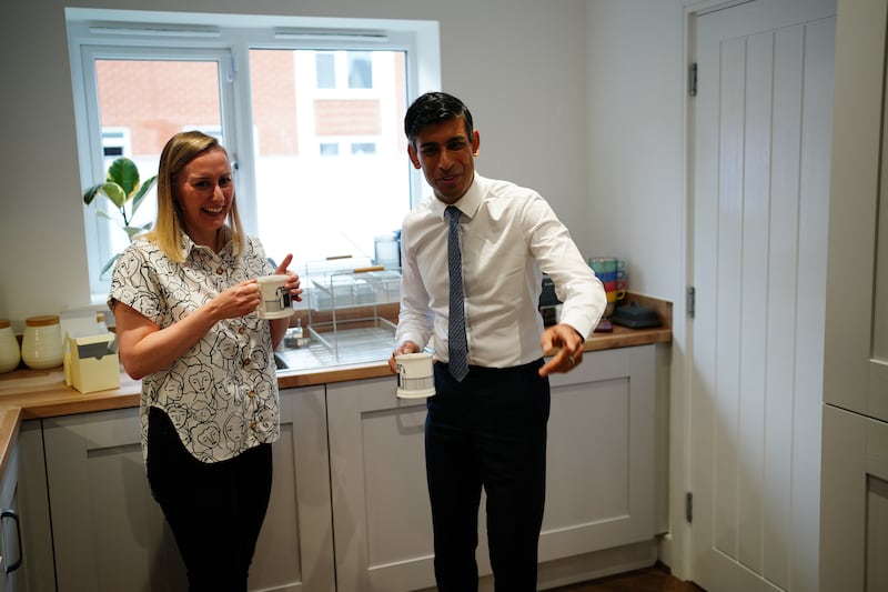 Prime Minister Rishi Sunak has a cup of tea with home-owner Jennifer Norton during a visit to Rednal, near Birmingham, in July 2023