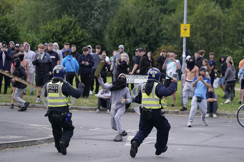 A youth aims a fence post towards police during an anti-immigration demonstration near the Holiday Inn Express in Rotherham, South Yorkshire, on Sunday August 4