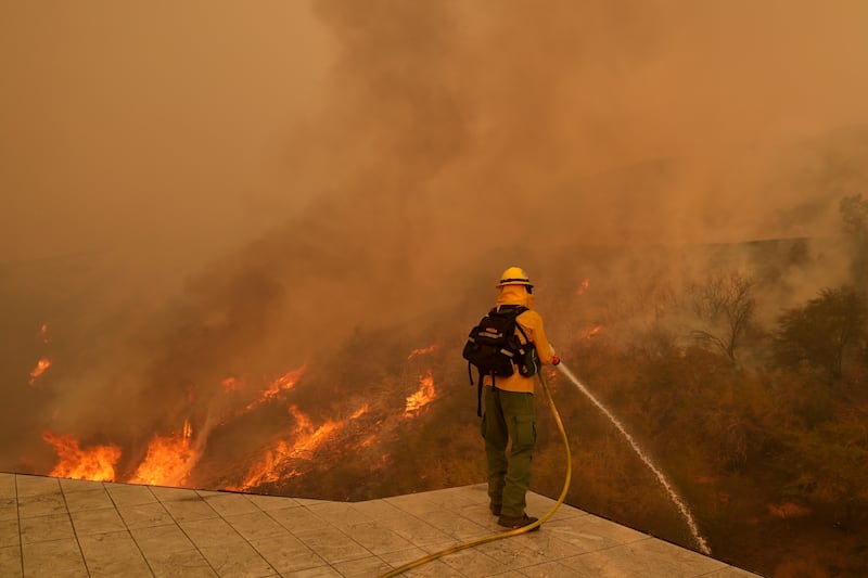 A firefighter hoses down flames In Los Angeles. (Jae C Hong/AP)