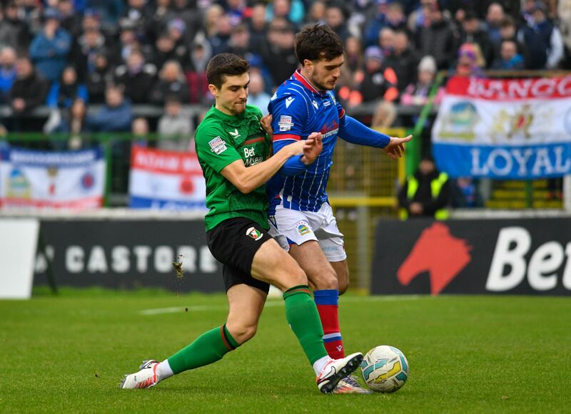 Cameron Palmer of Glentoran tackles Euan East of Linfield during this Evening’s game at The Bet McLean Oval, Belfast