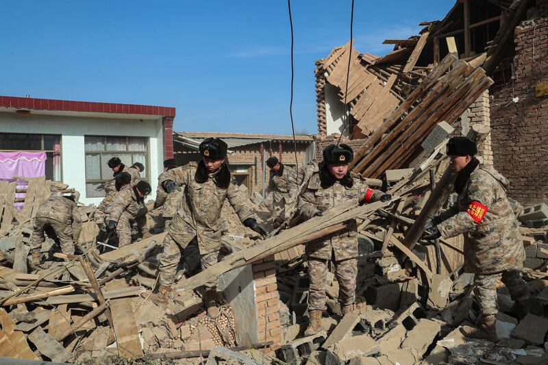 Soldiers clear debris on the damaged houses after the earthquake in Chenjia Village of Dahejia Township, Jishishan County (Feng Yanrong/Xinhua via AP)