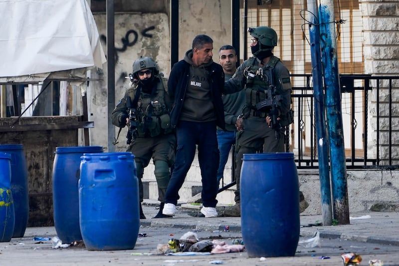 Israeli security forces arrest two Palestinian men during a military raid in the Askar refugee camp near the West Bank city of Nablus (Majdi Mohammed/AP)