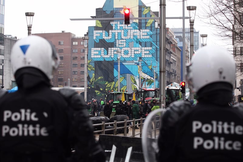 Police face farmers and tractors at a security checkpoint in Brussels (Nicolas Landemard/AP)