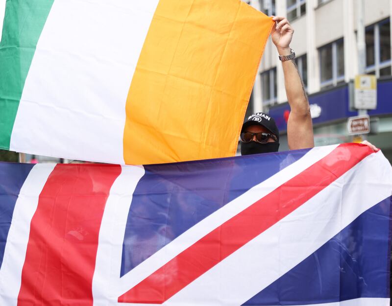 People taking part in an anti-immigration protest outside Belfast City Hall held the Irish flag and the Union flag