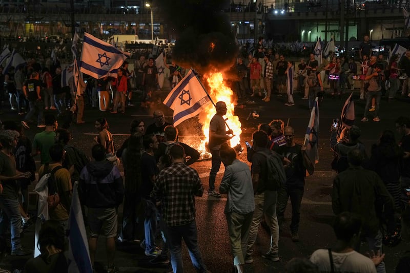 Israelis in Tel Aviv light a bonfire during a protest after Prime Minister Benjamin Netanyahu has dismissed his defence minister Yoav Gallant in a surprise announcement (Oded Balilty/AP)