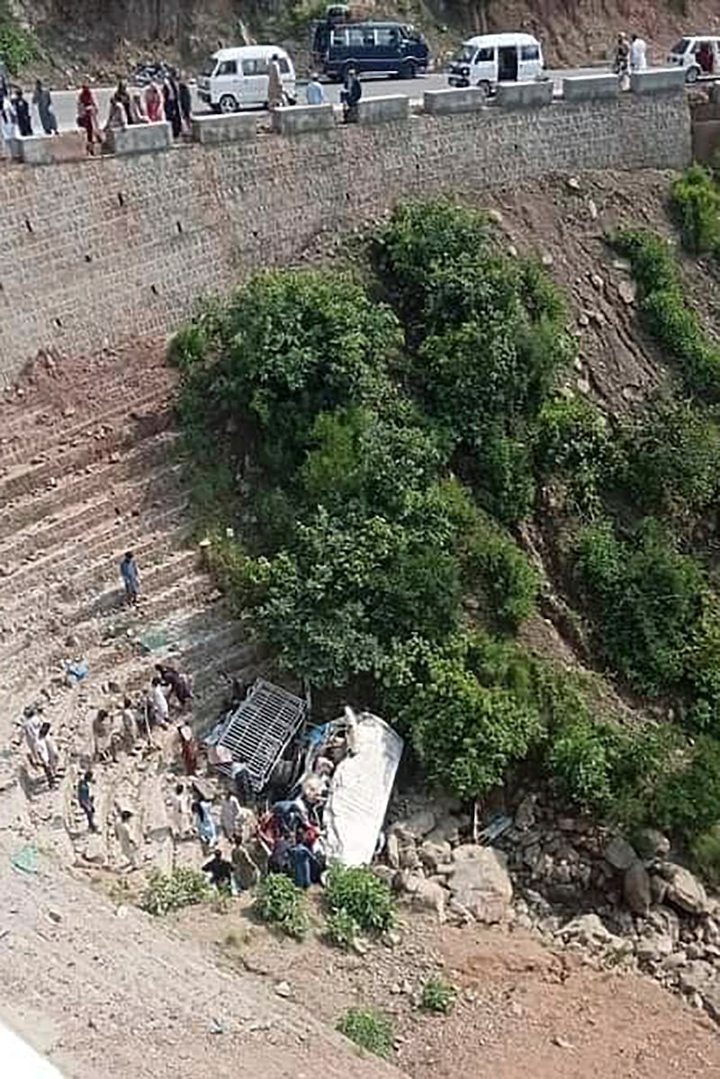 Rescuers at the scene of the bus crash in a ravine, near Kahuta, Pakistan (AP)